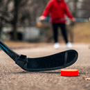 Bauer off-ice blade protector in black shown on hockey stick with orange street puck outdoors