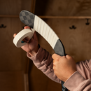 Hands wrapping white hockey tape around the blade of a Bauer ice hockey stick