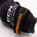 Close-up detail of CCM Tacks elbow pad strap showing size label and branding