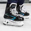 Bauer Supreme Fuse Junior ice hockey skates with teal accents on ice surface