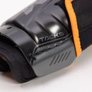 Close-up detail of CCM Tacks shin guard showing hard shell protection and orange accent strap