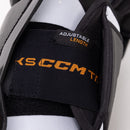 Close-up detail of CCM Tacks shin guard showing adjustable length strap feature in black